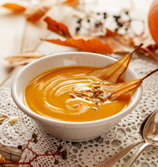 Pumpkin soup with the addition of pear chips in a white ceramic bowl. Delicious and healthy vegetarian soup