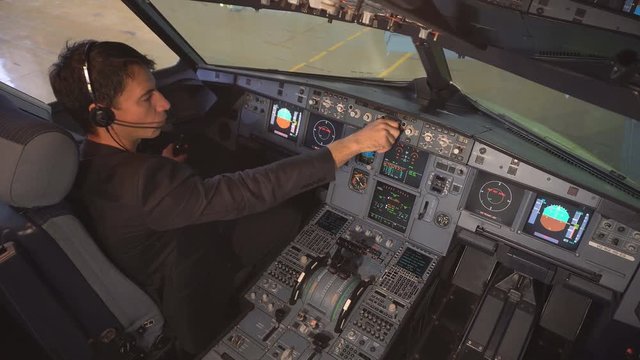 The cockpit of the aircraft. The pilot checks the plane before takeoff. Preparation of passenger airliner for takeoff. The pilot adjusts the autopilot. 4k