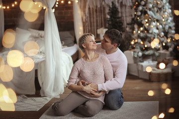 Obraz na płótnie Canvas man and a woman are hugging together, Christmas