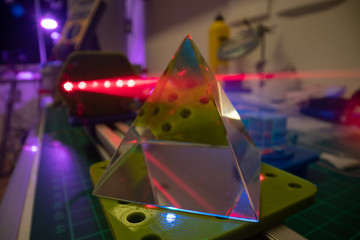 Experiments with lasers in the optics lab. Red laser on optical table in physics laboratory