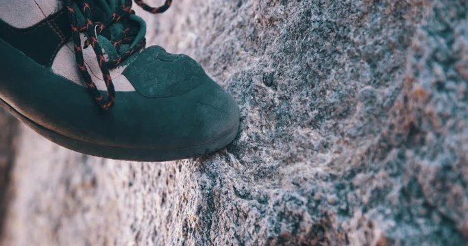 Close up of climbing shoe on tan granite rock