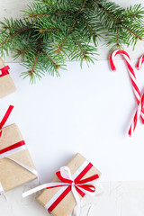 Clear paper laying with candy cane, Christmas tree branches and gifts