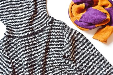 Striped sweater and orange and purple scarf. Flat lay trendy winter clothes. Stylish apparel and accessories