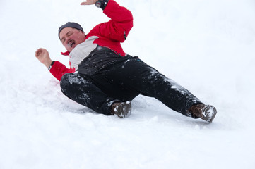 Fototapeta na wymiar Mann mit rotem Anorak stürzt im Schnee