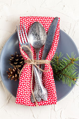 Christmas menu background with fork knife napkin and fir tree brunch on white table. top view
