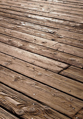 Worn wooden planks with nails in them on a weathered ocean pier