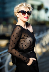 portrait of adult fashionable woman in sunglasses at city