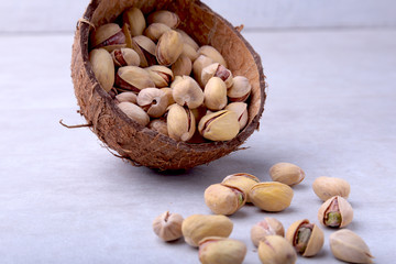 handmade bowl of coconut with pistachios isolated on a white background. Close-up.