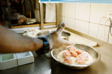 chef cooks cutlets in breading