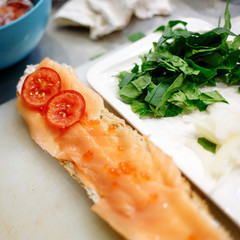 chef prepares a baguette with salmon