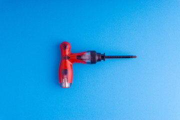 Screwdriver on blue background with selective focus and crop fragment