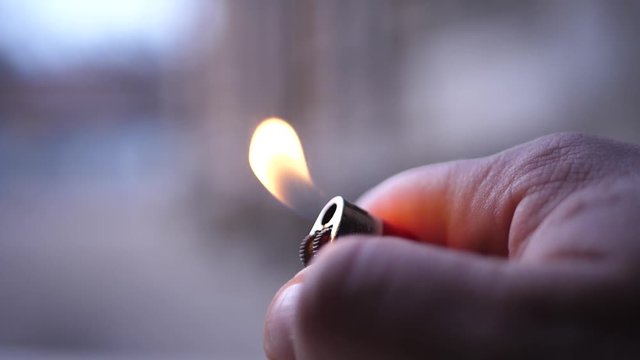 Burning red lighter in hand outdoor