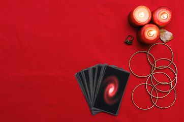 Tarot cards on the red table cloth on fortune teller table background. Futune reading concept.