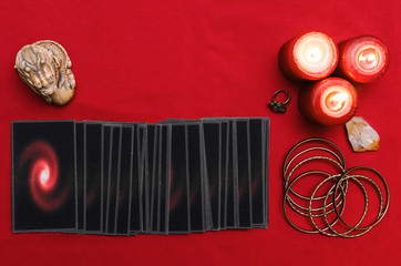 Tarot cards on the red table cloth on fortune teller table background. Futune reading concept.