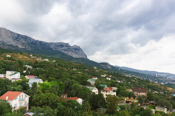 Fototapeta na wymiar View of the resort village of Alupka and AI-Petri mountain on a cloudy day