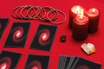 Tarot cards on the red table cloth on fortune teller table background. Futune reading concept.