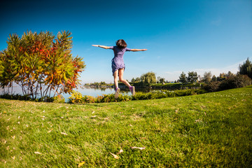 Fototapeta premium Girl jumping on the grass.