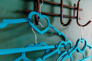 blue рeart clothes hanger on green background. two clothes hanger being in love,lovely concept.