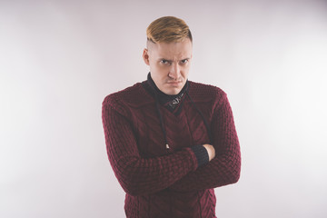 charismatic man dressed in a red sweater and posing on a white background