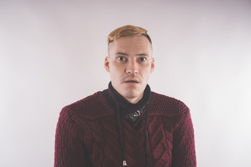 charismatic man dressed in a red sweater and posing on a white background