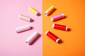Set of colorful sewing threads on bright background.