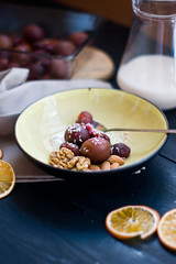 Dessert plums and walnuts on wooden background