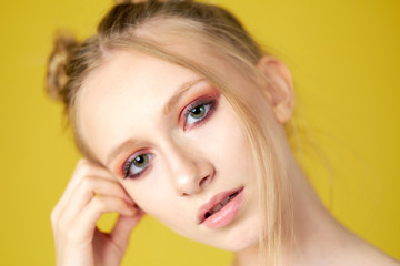 Obraz premium young girl on a yellow bright background. beautiful makeup, bright image, place for text