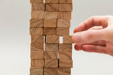 Male hand stacking wooden blocks. Business development and growth concept