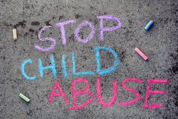 Colorful chalk drawing on asphalt: words STOP CHILD ABUSE - 232358903