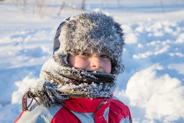 Adorable smiling boy at the snow background