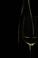 Light shapes on glass and bottle of wine in dark background
