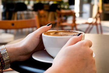 woman hand drinking coffee in cafe