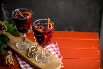 Christmas composition with spicy mulled wine and pine cones on dark background