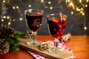 Christmas composition with spicy mulled wine, led lights and pine cones on dark background