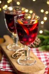 Christmas composition with spicy mulled wine, led lights and pine cones on dark background