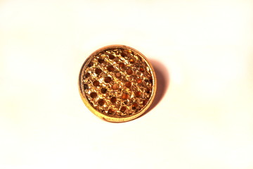 Golden decorated button on a white background