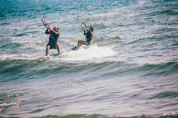 Professional kiter makes the difficult trick on a beautiful background. Kitesurfing Kiteboarding action photos man among waves quickly goes