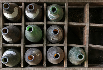 Fototapeta premium Old beer empty dirty bottles in a damaged wooden crate