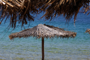 Fototapeta na wymiar Reed umbrellas near the sea