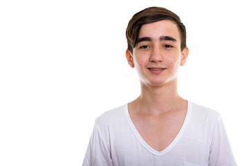 Studio shot of young happy Persian teenage boy smiling