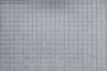 Silberne Wand mit quadratischen kleinen Fliesen oder Kacheln nutzbar als dekorativer Hintergrund oder Textur.