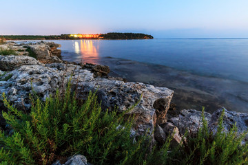 Enjoying the colorful sunset on a beach with rocks on the Adriatic Sea coast Istria Croatia
