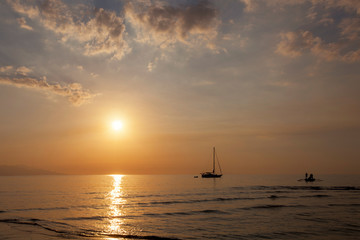 Naklejka na ściany i meble Beautiful dusk on the beach and silhouette of fishing boat and sailing boat