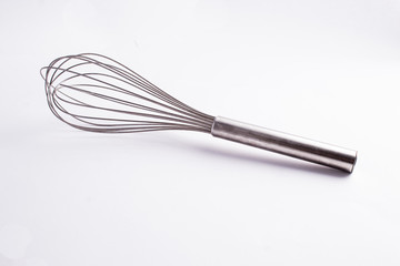 Kitche whisk or egg beater isolated on white background; sensation of fresh and clean kitchen