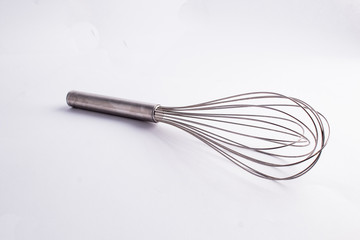 Kitche whisk or egg beater isolated on white background; sensation of fresh and clean kitchen