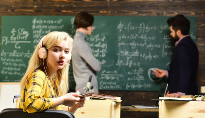 High school or college students studying and reading together in library. Students sitting together at table. Old books on a round wooden table. Successful tutors are always on time and prepared.