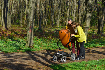 Babysitters walk with baby pram in park. Woman and man babysitters take care of little child. Responsibility and reliability. Reliable care for precious little ones