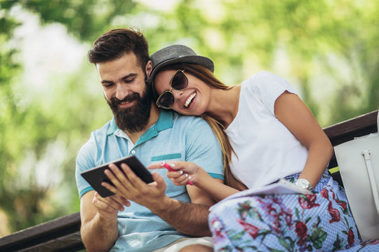 Young attractive couple talking and looking at digital tablet.