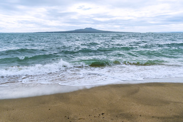 Landscape Scenery during Sunrise Time at Takapuna Beach, Auckland New Zealand; View to Rangitoto Island; Rough Seas