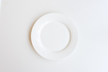 Ceramic plate on white background from above (selective focus)